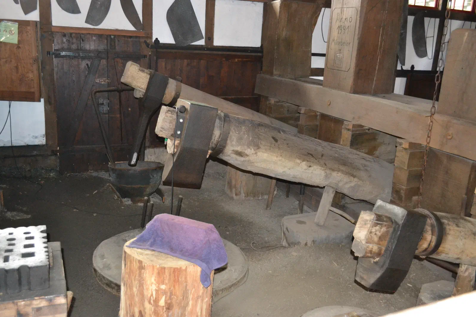 Marteau-pilon historique au Tobiashammer d&rsquo;Ohrdruf : lourds marteaux fixés à de longues poutres en bois au-dessus d&rsquo;une enclume dans l&rsquo;ancienne halle de forge
