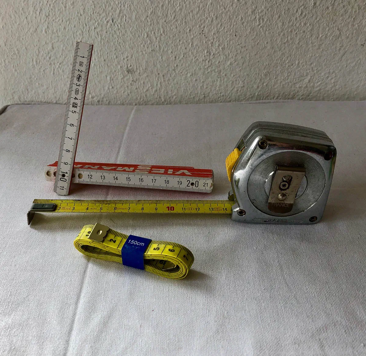Unsuitable measuring tools: a short, thin folding rule, a steel tape measure and a rolled-up tailor’s tape measure